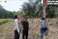 Kapolsek Buay Madang Timur (BMT) Iptu Swisspo, memantau pemasangan spanduk imbauan larangan membakar lahan di kawasan perkebunan Desa Tambak Boyo, OKU Timur, Sumatera Selatan.