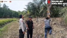 Kapolsek Buay Madang Timur (BMT) Iptu Swisspo, memantau pemasangan spanduk imbauan larangan membakar lahan di kawasan perkebunan Desa Tambak Boyo, OKU Timur, Sumatera Selatan.