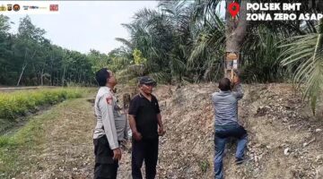 Kapolsek Buay Madang Timur (BMT) Iptu Swisspo, memantau pemasangan spanduk imbauan larangan membakar lahan di kawasan perkebunan Desa Tambak Boyo, OKU Timur, Sumatera Selatan.