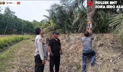 Kapolsek Buay Madang Timur (BMT) Iptu Swisspo, memantau pemasangan spanduk imbauan larangan membakar lahan di kawasan perkebunan Desa Tambak Boyo, OKU Timur, Sumatera Selatan.