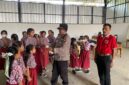 Kapolsek Buay Madang Timur (BMT) Iptu Swisspo, membagikan masker gratis kepada siswi SDN 1 Bali Luhur di Desa Suka Maju, OKU Timur, Sumatera Selatan.