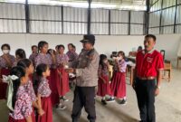 Kapolsek Buay Madang Timur (BMT) Iptu Swisspo, membagikan masker gratis kepada siswi SDN 1 Bali Luhur di Desa Suka Maju, OKU Timur, Sumatera Selatan.