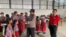 Kapolsek Buay Madang Timur (BMT) Iptu Swisspo, membagikan masker gratis kepada siswi SDN 1 Bali Luhur di Desa Suka Maju, OKU Timur, Sumatera Selatan.
