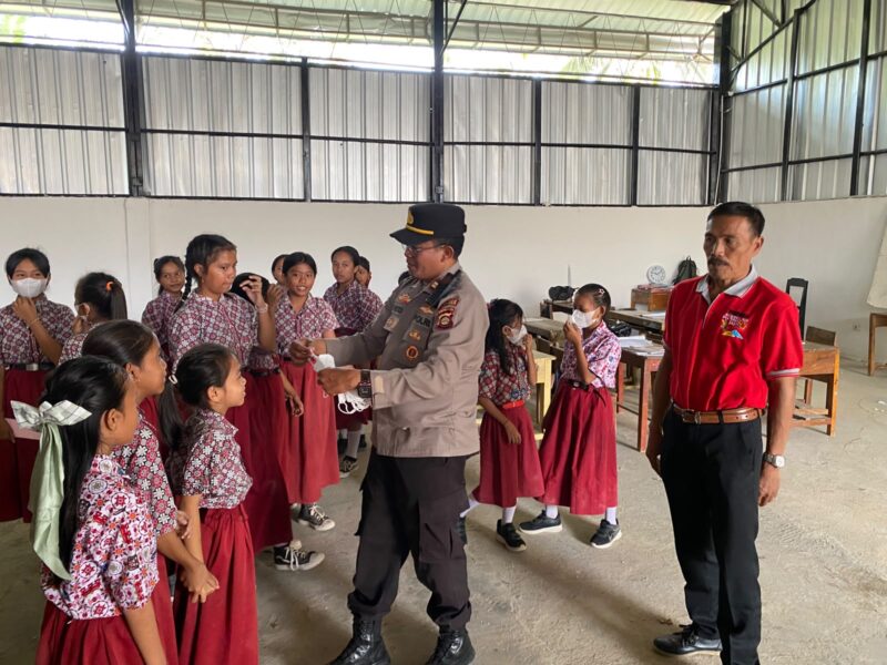 Kapolsek Buay Madang Timur (BMT) Iptu Swisspo, membagikan masker gratis kepada siswi SDN 1 Bali Luhur di Desa Suka Maju, OKU Timur, Sumatera Selatan.