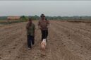 Kapolsek Buay Madang Timur Iptu Swisspo, menggunakan alat penanam manual didampingi pemilik lahan, Wakidin, saat menanam jagung hibrida di Desa Tanjung Mas.
