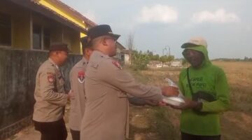 Kapolsek BMT Iptu Swisspo menyerahkan paket makanan siap santap kepada seorang warga di kawasan Desa Kumpul Rejo, Kecamatan Buay Madang Timur, Kabupaten OKU Timur.