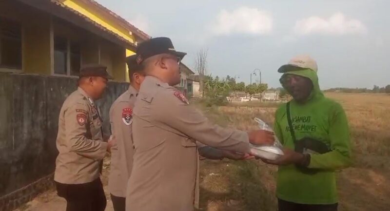 Kapolsek BMT Iptu Swisspo menyerahkan paket makanan siap santap kepada seorang warga di kawasan Desa Kumpul Rejo, Kecamatan Buay Madang Timur, Kabupaten OKU Timur.