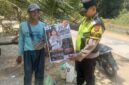 Personel Polsek Buay Madang Timur menunjukkan poster maklumat larangan membakar hutan dan lahan bersama seorang warga saat menggelar kegiatan mitigasi di wilayah Kecamatan Buay Madang Timur, Kabupaten OKU Timur.