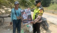 Personel Polsek Buay Madang Timur menunjukkan poster maklumat larangan membakar hutan dan lahan bersama seorang warga saat menggelar kegiatan mitigasi di wilayah Kecamatan Buay Madang Timur, Kabupaten OKU Timur.