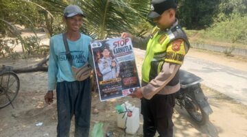 Personel Polsek Buay Madang Timur menunjukkan poster maklumat larangan membakar hutan dan lahan bersama seorang warga saat menggelar kegiatan mitigasi di wilayah Kecamatan Buay Madang Timur, Kabupaten OKU Timur.