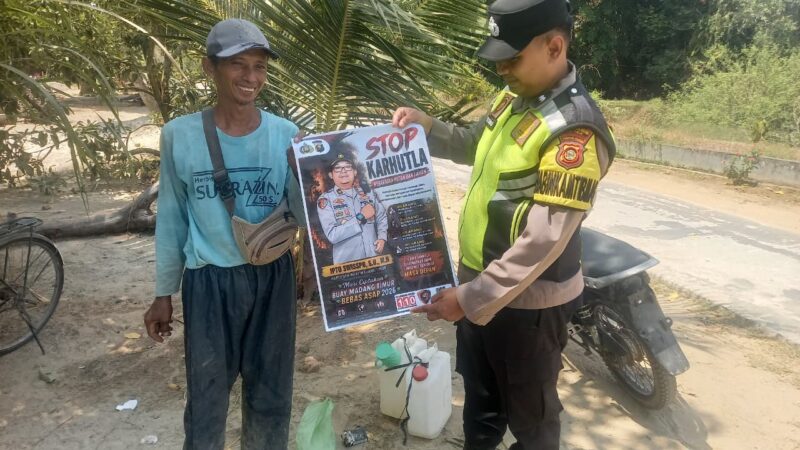 Personel Polsek Buay Madang Timur menunjukkan poster maklumat larangan membakar hutan dan lahan bersama seorang warga saat menggelar kegiatan mitigasi di wilayah Kecamatan Buay Madang Timur, Kabupaten OKU Timur.
