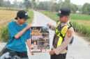 Personel Polsek Buay Madang Timur menunjukkan poster Maklumat Kapolda Sumsel tentang larangan membakar hutan dan lahan kepada seorang pengendara motor di kawasan Desa Tanjung Mulya, Kecamatan Buay Madang Timur, Kabupaten OKU Timur.