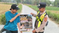 Personel Polsek Buay Madang Timur menunjukkan poster Maklumat Kapolda Sumsel tentang larangan membakar hutan dan lahan kepada seorang pengendara motor di kawasan Desa Tanjung Mulya, Kecamatan Buay Madang Timur, Kabupaten OKU Timur.