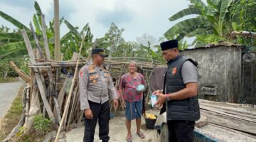 Kapolsek Buay Madang Timur Iptu Swisspo, didampingi Kanit IK Aiptu Dahrul Hutni menyerahkan paket bantuan makanan langsung kepada warga lansia di Desa Tambak Boyo, Kecamatan BMT, Kabupaten OKU Timur.