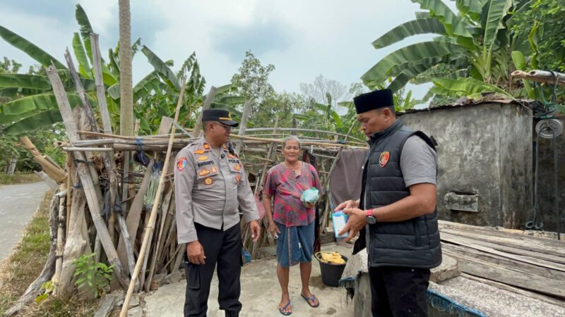 Kapolsek Buay Madang Timur Iptu Swisspo, didampingi Kanit IK Aiptu Dahrul Hutni menyerahkan paket bantuan makanan langsung kepada warga lansia di Desa Tambak Boyo, Kecamatan BMT, Kabupaten OKU Timur.