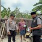 Kapolsek Buay Madang Timur Iptu Swisspo, didampingi Kanit IK Aiptu Dahrul Hutni menyerahkan paket bantuan makanan langsung kepada warga lansia di Desa Tambak Boyo, Kecamatan BMT, Kabupaten OKU Timur.