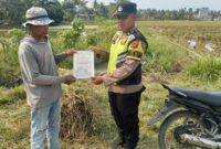 Personel Bhabinkamtibmas Polsek Buay Madang Timur menyerahkan lembaran Maklumat Kapolda Sumsel tentang larangan membakar hutan dan lahan (Karhutla) langsung kepada seorang petani di area persawahan Desa Kumpul Rejo, Kecamatan Buay Madang Timur, Kabupaten OKU Timur.