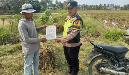 Personel Bhabinkamtibmas Polsek Buay Madang Timur menyerahkan lembaran Maklumat Kapolda Sumsel tentang larangan membakar hutan dan lahan (Karhutla) langsung kepada seorang petani di area persawahan Desa Kumpul Rejo, Kecamatan Buay Madang Timur, Kabupaten OKU Timur.