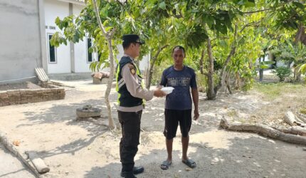 Personel Polsek Buay Madang Timur, Aipda Zulkifli, menyerahkan paket makanan siap saji secara langsung kepada seorang warga di Desa Kedu, Kecamatan Buay Madang Timur, Kabupaten OKU Timur.