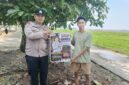Personel Polsek Buay Madang Timur, Aipda Wisnu Saputra, memberikan pamflet Maklumat Kapolda Sumsel mengenai larangan pembakaran hutan dan lahan kepada salah seorang warga di Kecamatan Buay Madang Timur, Kabupaten OKU Timur.