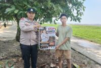 Personel Polsek Buay Madang Timur, Aipda Wisnu Saputra, memberikan pamflet Maklumat Kapolda Sumsel mengenai larangan pembakaran hutan dan lahan kepada salah seorang warga di Kecamatan Buay Madang Timur, Kabupaten OKU Timur.