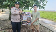 Personel Polsek Buay Madang Timur, Aipda Wisnu Saputra, memberikan pamflet Maklumat Kapolda Sumsel mengenai larangan pembakaran hutan dan lahan kepada salah seorang warga di Kecamatan Buay Madang Timur, Kabupaten OKU Timur.