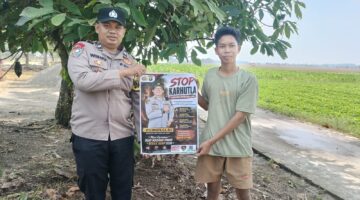 Personel Polsek Buay Madang Timur, Aipda Wisnu Saputra, memberikan pamflet Maklumat Kapolda Sumsel mengenai larangan pembakaran hutan dan lahan kepada salah seorang warga di Kecamatan Buay Madang Timur, Kabupaten OKU Timur.