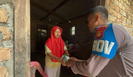 Kanit Provos Polsek Buay Madang Timur, Bripka Didi Handoko, menyerahkan paket bantuan makanan kepada salah seorang lansia di Desa Karang Tengah, Kecamatan Buay Madang Timur, Kabupaten OKU Timur.