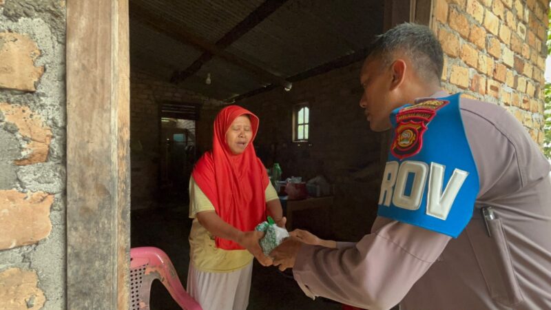 Kanit Provos Polsek Buay Madang Timur, Bripka Didi Handoko, menyerahkan paket bantuan makanan kepada salah seorang lansia di Desa Karang Tengah, Kecamatan Buay Madang Timur, Kabupaten OKU Timur.