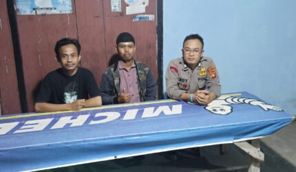 Personel Polsek Buay Madang Timur (BMT), Brigadir Tedy Heryadi, duduk bersama warga saat melaksanakan kegiatan silaturahmi dan sambang dialogis malam hari di Desa Kumpul Rejo, Kecamatan Buay Madang Timur, Kabupaten OKU Timur.