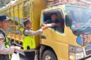 Personel Polsek Buat Madang Timur menyerahkan paket makanan gratis kepada seorang sopir truk di kawasan Desa Kedu, Kecamatan Buay Madang Timur, Kabupaten OKU Timur.