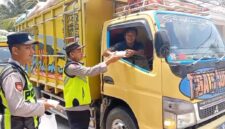 Personel Polsek Buat Madang Timur menyerahkan paket makanan gratis kepada seorang sopir truk di kawasan Desa Kedu, Kecamatan Buay Madang Timur, Kabupaten OKU Timur.