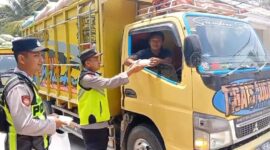 Personel Polsek Buat Madang Timur menyerahkan paket makanan gratis kepada seorang sopir truk di kawasan Desa Kedu, Kecamatan Buay Madang Timur, Kabupaten OKU Timur.