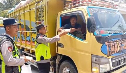 Personel Polsek Buat Madang Timur menyerahkan paket makanan gratis kepada seorang sopir truk di kawasan Desa Kedu, Kecamatan Buay Madang Timur, Kabupaten OKU Timur.