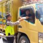 Personel Polsek Buat Madang Timur menyerahkan paket makanan gratis kepada seorang sopir truk di kawasan Desa Kedu, Kecamatan Buay Madang Timur, Kabupaten OKU Timur.