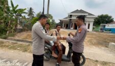 Personel Polsek Buat Madang Timur membagikan masker dan paket bantuan kepada pelajar yang melintas saat menggelar kegiatan sedekah dan berbagi di kawasan Desa Srikaton, Kecamatan Buay Madang Timur, Kabupaten OKU Timur.