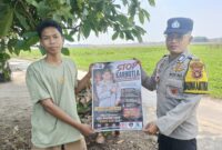 Anggota Bhabinkamtibmas Polsek Buay Madang Timur, Brigadir Tedy Heryadi, menunjukkan pamflet maklumat "Stop Karhutla" bersama seorang warga saat menggelar kegiatan mitigasi kebakaran hutan dan lahan di Kecamatan Buay Madang Timur, Kabupaten OKU Timur, Sumatera Selatan.