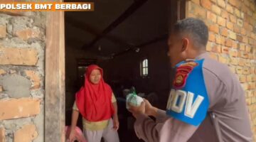 Personel Polsek Buay Madang Timur, Bripka Didi Handoko, menyerahkan paket makanan bantuan kepada seorang ibu rumah tangga di Desa Kedung Rejo, Kecamatan Buay Madang Timur, Kabupaten OKU Timur, Sumatera Selatan.