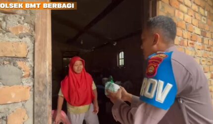 Personel Polsek Buay Madang Timur, Bripka Didi Handoko, menyerahkan paket makanan bantuan kepada seorang ibu rumah tangga di Desa Kedung Rejo, Kecamatan Buay Madang Timur, Kabupaten OKU Timur, Sumatera Selatan.
