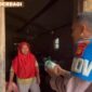 Personel Polsek Buay Madang Timur, Bripka Didi Handoko, menyerahkan paket makanan bantuan kepada seorang ibu rumah tangga di Desa Kedung Rejo, Kecamatan Buay Madang Timur, Kabupaten OKU Timur, Sumatera Selatan.