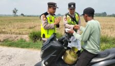 Ka Jaga Piket Polsek Buay Madang Timur Aipda Khoirul Alkaf menyerahkan paket makanan siap saji kepada seorang warga yang mengendarai sepeda motor di wilayah Kedu, Kecamatan Buay Madang Timur, Kabupaten OKU Timur.