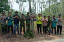 Kapolsek Buay Madang Timur Iptu Swisspo, bersama personel TNI, staf kecamatan, dan perangkat desa berfoto bersama usai memasang spanduk imbauan larangan membakar hutan dan lahan di Desa Teko Rejo, Kecamatan Buay Madang Timur, Kabupaten OKU Timur.