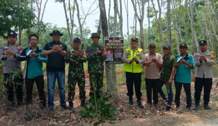 Kapolsek Buay Madang Timur Iptu Swisspo, bersama personel TNI, staf kecamatan, dan perangkat desa berfoto bersama usai memasang spanduk imbauan larangan membakar hutan dan lahan di Desa Teko Rejo, Kecamatan Buay Madang Timur, Kabupaten OKU Timur.