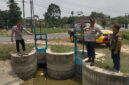 Kapolsek Buay Madang Timur Iptu Swisspo, didampingi Ps Kanit Provost Bripka Didi Handoko dan Ketua BPD Desa Sumber Harjo Yudi Panjalu, meninjau langsung kondisi pintu air saluran irigasi di Kecamatan Buay Madang Timur, OKU Timur.