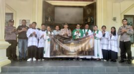 Kapolsek Buay Madang Timur Iptu Swisspo, didampingi personel Polsek, Romo Emilianus SCJ, dan pengurus gereja membentangkan spanduk program 