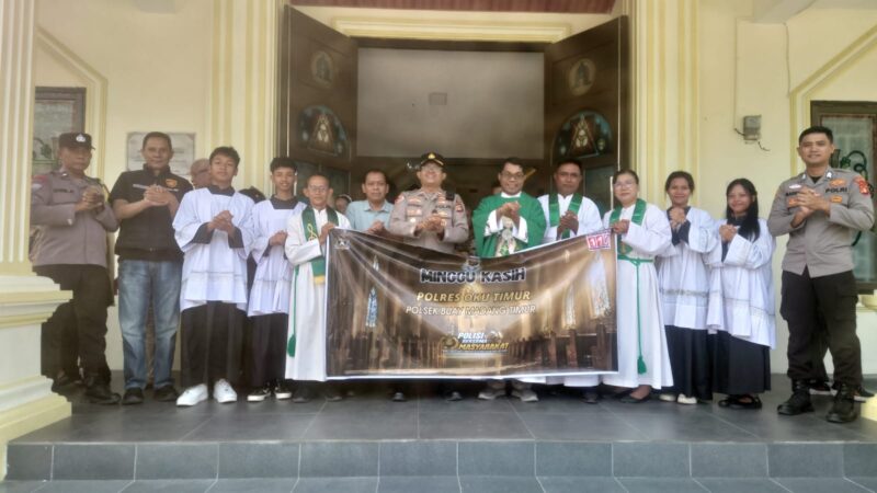 Kapolsek Buay Madang Timur Iptu Swisspo, didampingi personel Polsek, Romo Emilianus SCJ, dan pengurus gereja membentangkan spanduk program 