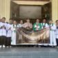 Kapolsek Buay Madang Timur Iptu Swisspo, didampingi personel Polsek, Romo Emilianus SCJ, dan pengurus gereja membentangkan spanduk program 