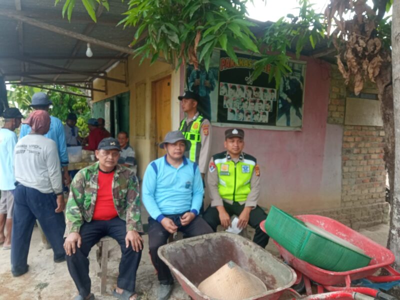 Personel Polsek Buay Madang Timur, Aipda Khoirul Alkaf dan Brigadir Rusendi Ardianto, duduk bersama warga saat menggelar kegiatan sambang dialogis di Desa Tanjung Agung, Kecamatan Buay Madang Timur, Kabupaten OKU Timur.
